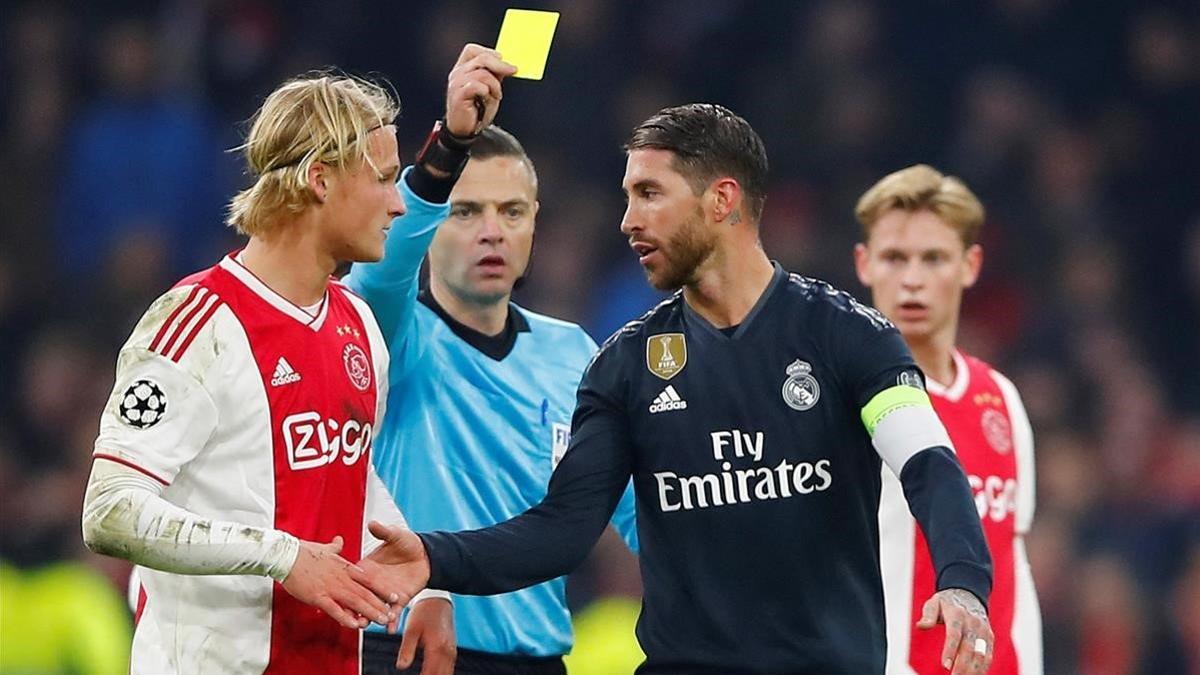 Ramos se disculpa con Dolberg, del Ajax, tras la amarilla provocada.