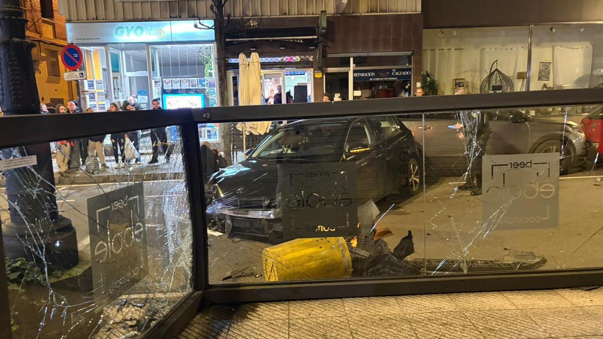 El coche y la terraza que sufrió graves daños.
