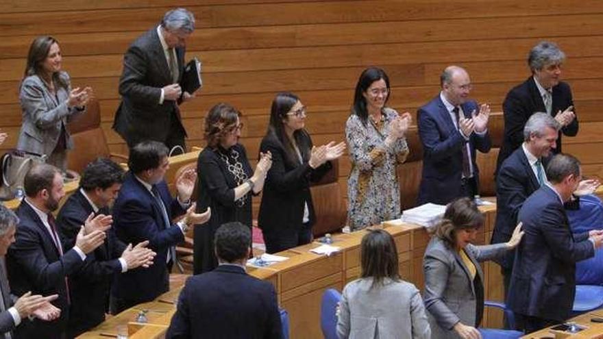 Feijóo, a la derecha, es aplaudido por los diputados del PP con parte de sus conselleiros en primera fila, ayer en el Parlamento.