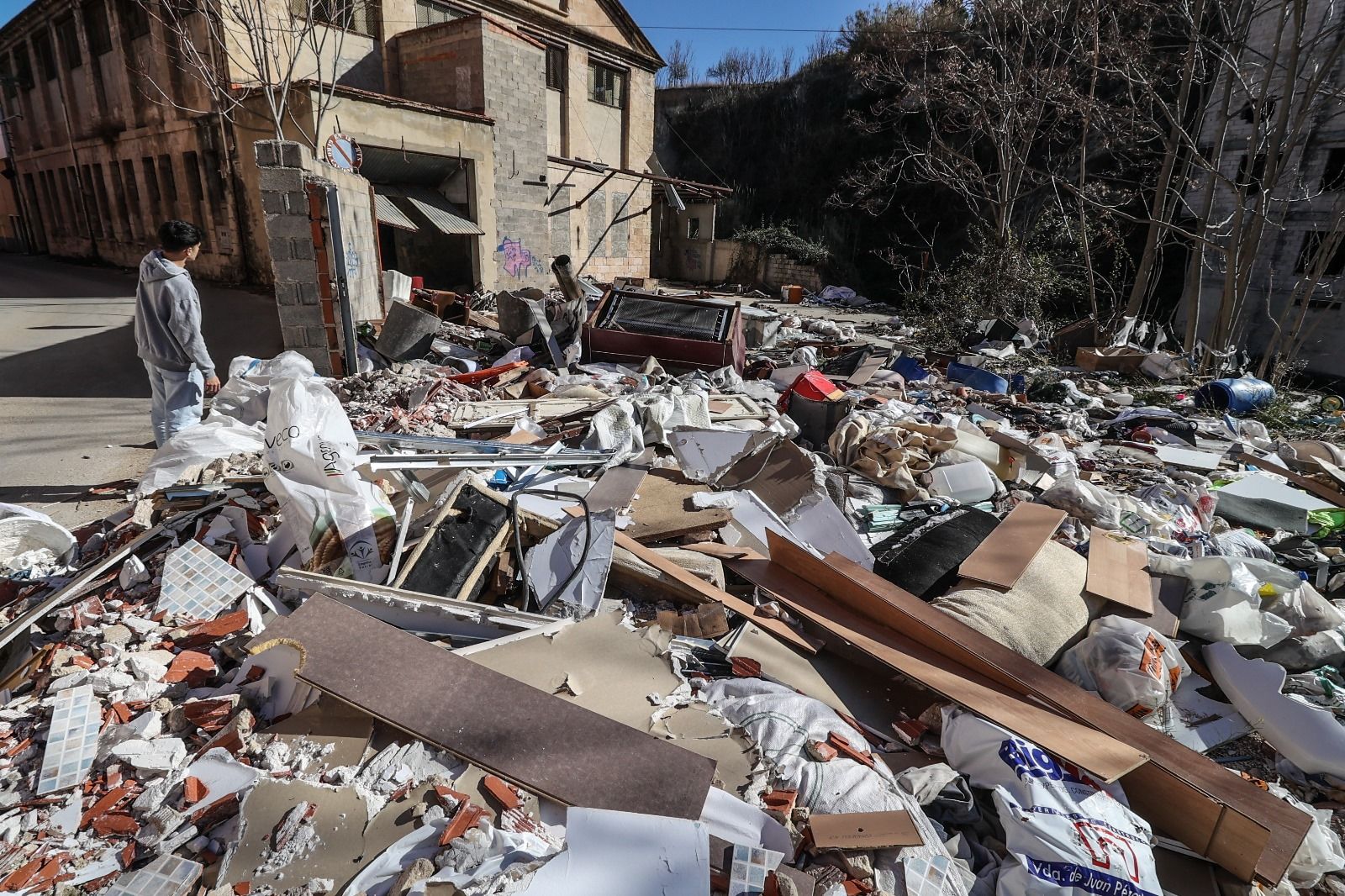 Escombros y basura acumulados junto al río Serpis y las fábricas de la calle Escalò de Alcoy