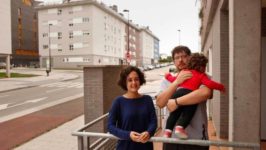 Betty Menéndez y David Álvarez, con su bebé de 18 meses, junto al edificio donde viven.