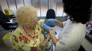 Una enfermera vacuna a una paciente en el CAP del Raval Nord.