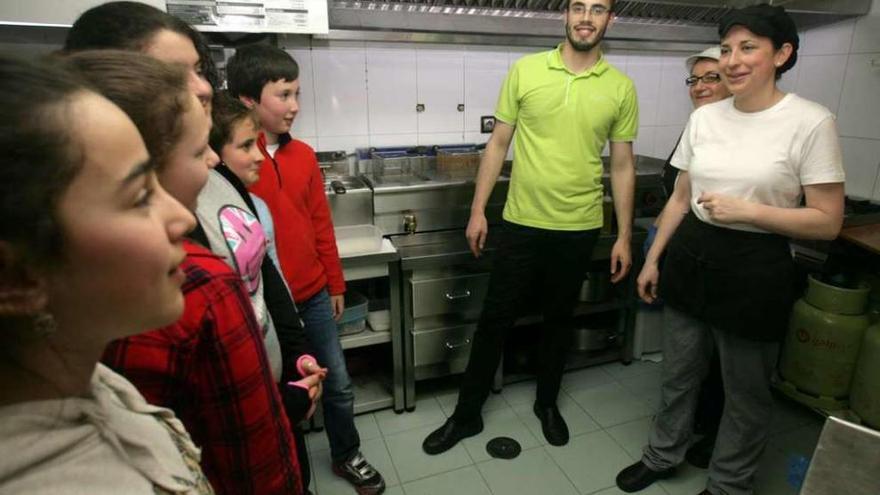 Escolares de O Foxo y personal del Invictus, ayer, en la cocina del establecimiento. // Bernabé / Víctor Espiño