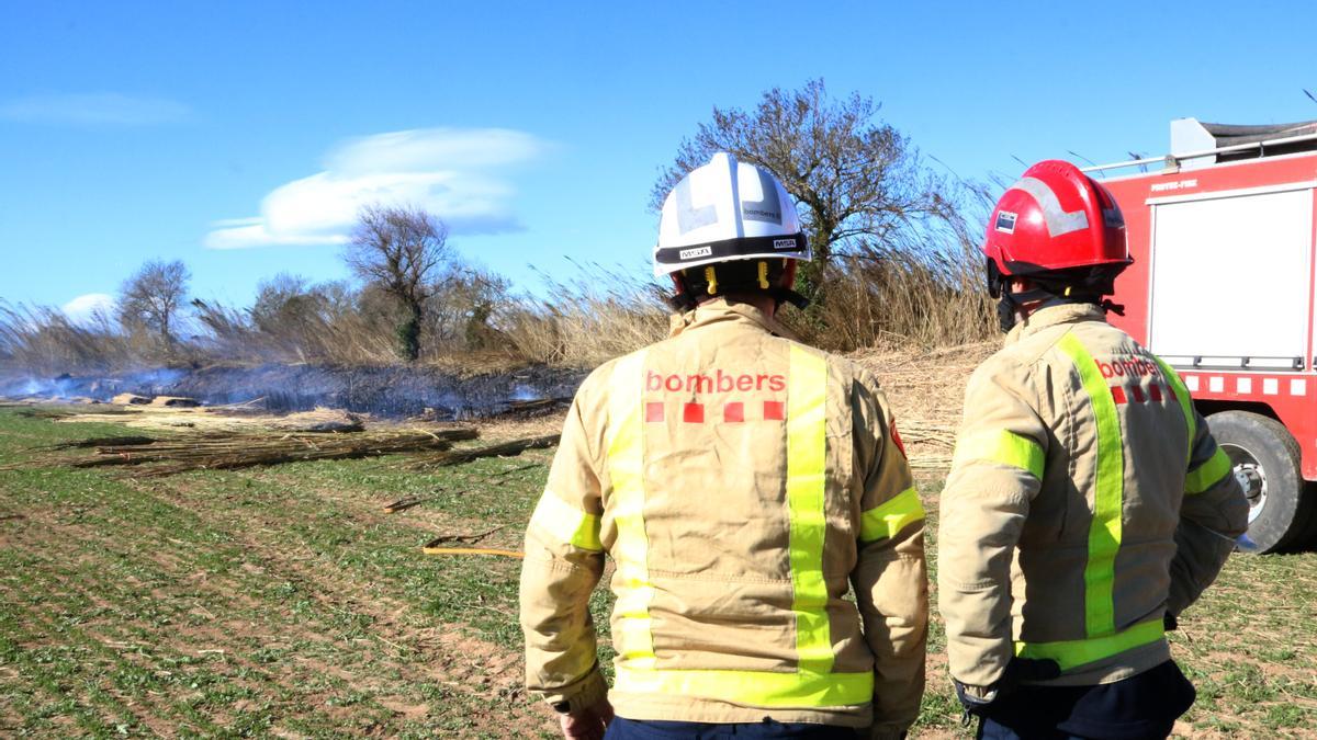 Dos bombers en una zona cremada per l'incendi de Peralada