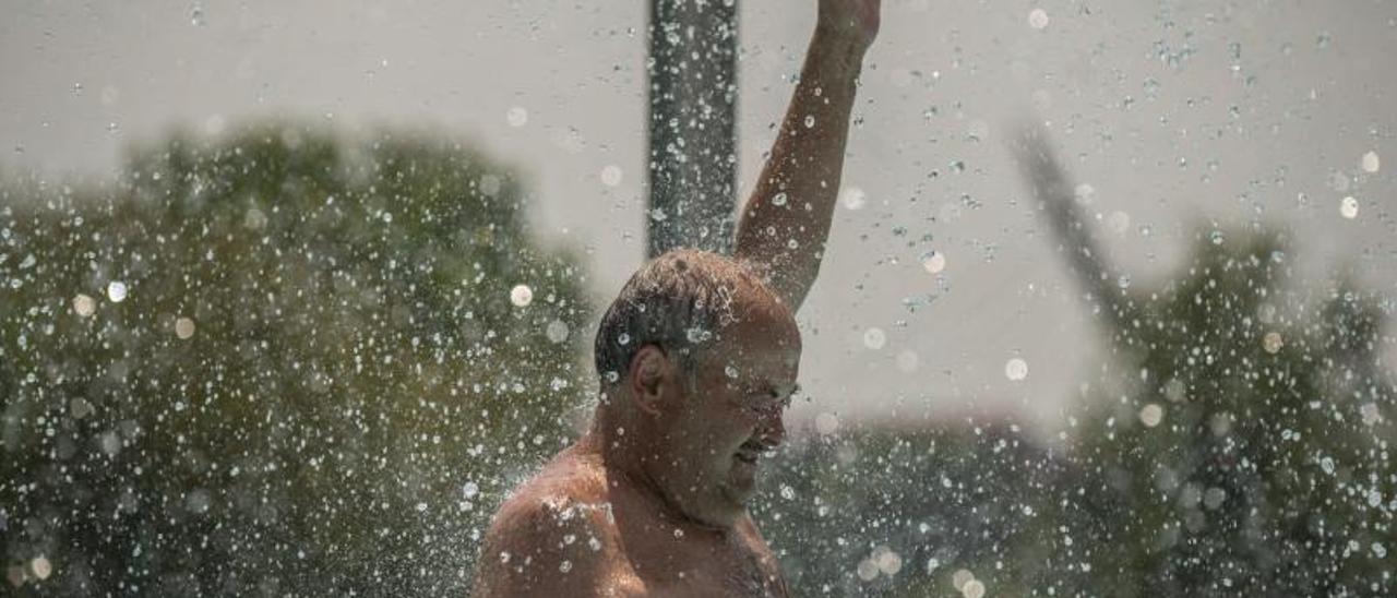 Un hombre se refrescaen las piscinas del complejo deportivo de Oira. |   // BRAIS LORENZO