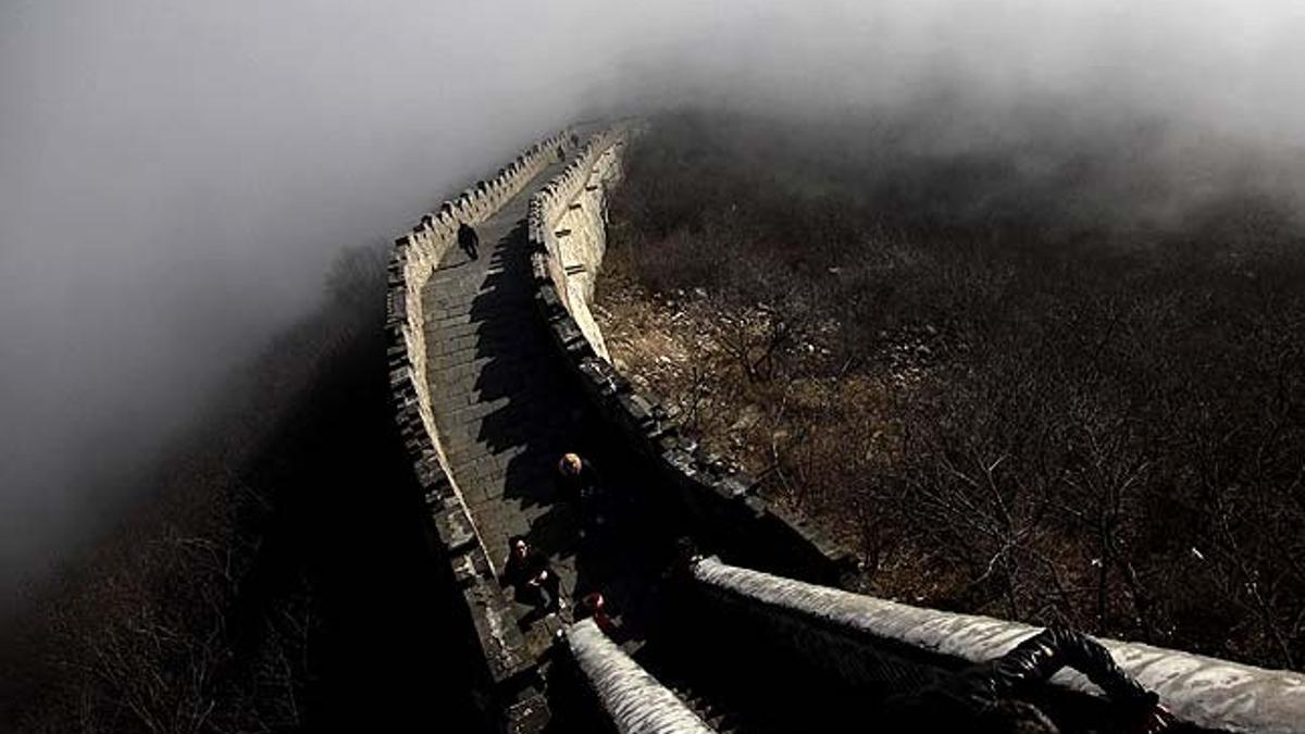 Turistas caminan por la Gran Muralla China cubierta de niebla en Simatai, a las afueras de Beijing (China).