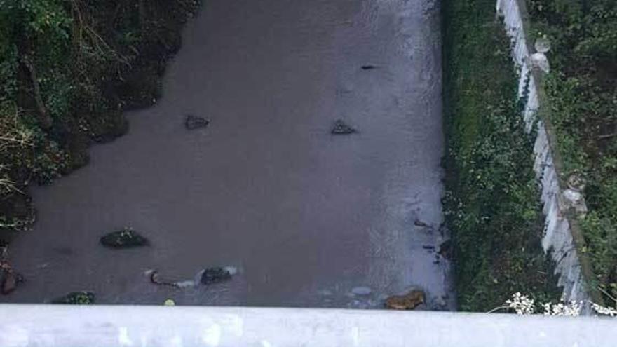 El río, teñido de gris, en uno de los vertidos denunciados por los vecinos de Campomanes.