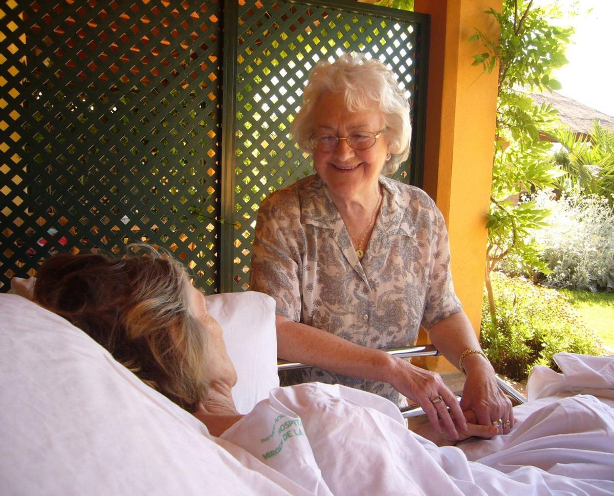 Joan Hunt, fundadora de Cudeca, con una paciente. | CUDECA