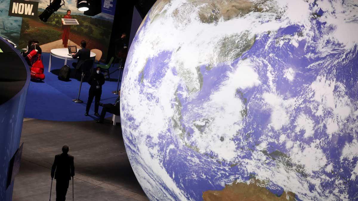 Aspecto del interior del centro de convenciones donde se celebra el COP26, con un planeta Tierra gigante.