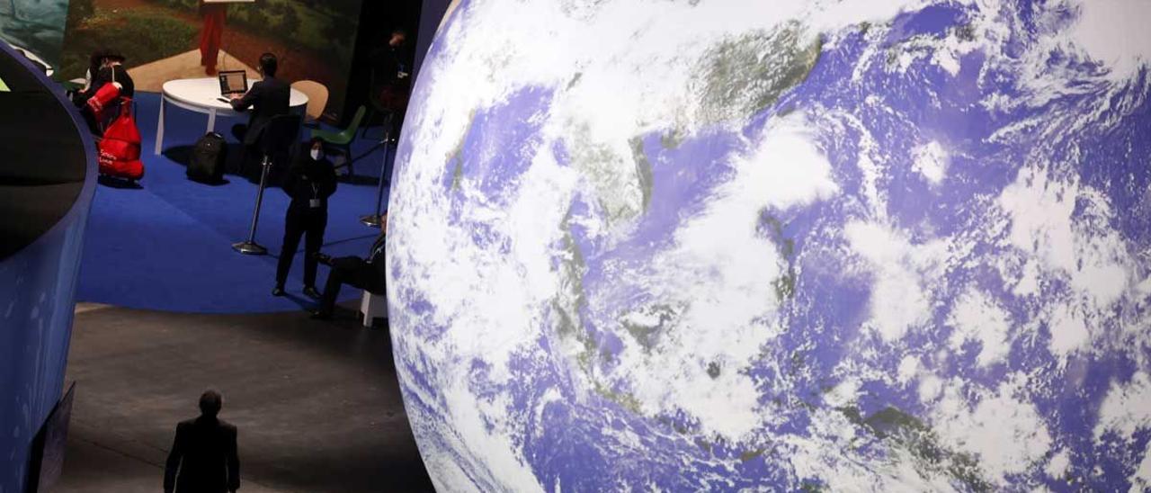 Aspecto del interior del centro de convenciones donde se celebra el COP26, con un planeta Tierra gigante.