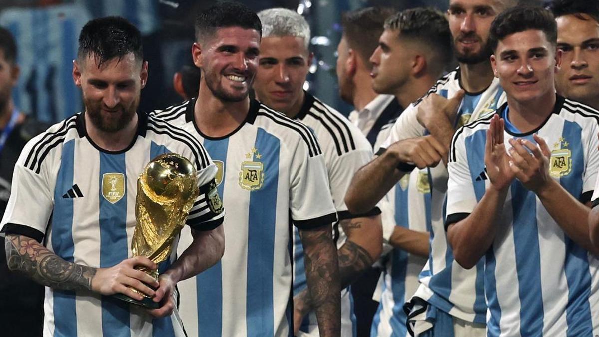 Leo Messi sujeta la Copa del Mundo, rodeado de sus compañeros, en el último amistoso contra Argentina.