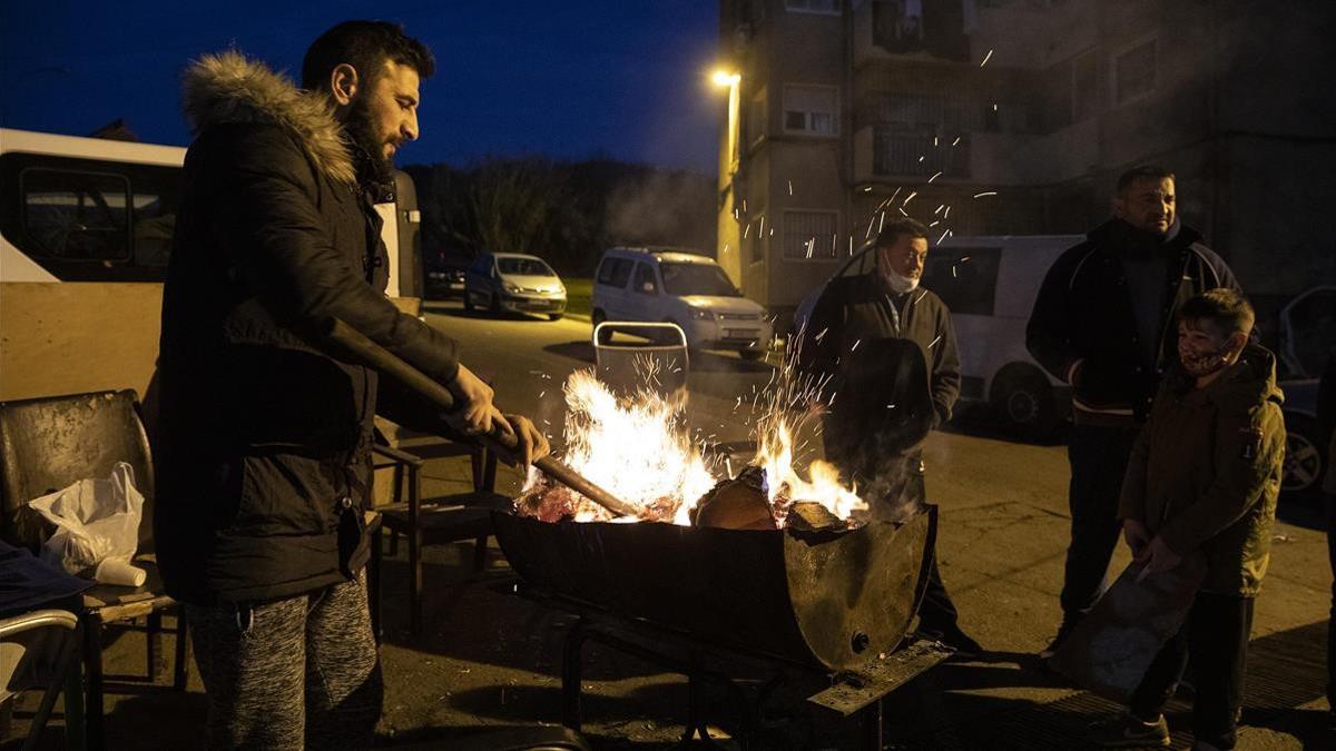 Un grupo de vecinos se calientan en un fuego en la calle porque en sus casas no hay electricidad para encender la calefacción.