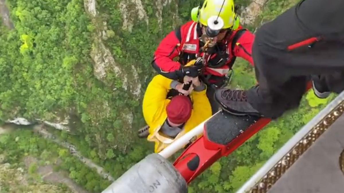 El británico rescatado, de amarillo, izado al helicóptero.