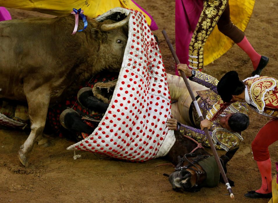 El torero Rafael Torres cae del caballo mientras un toro le ataca durante el festival de Canaveralejo en Cali, Colombia.