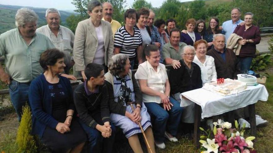 Pilar García (sentada, tercera por la derecha), en su fiesta de cumpleaños, rodeada de vecinos y familiares.