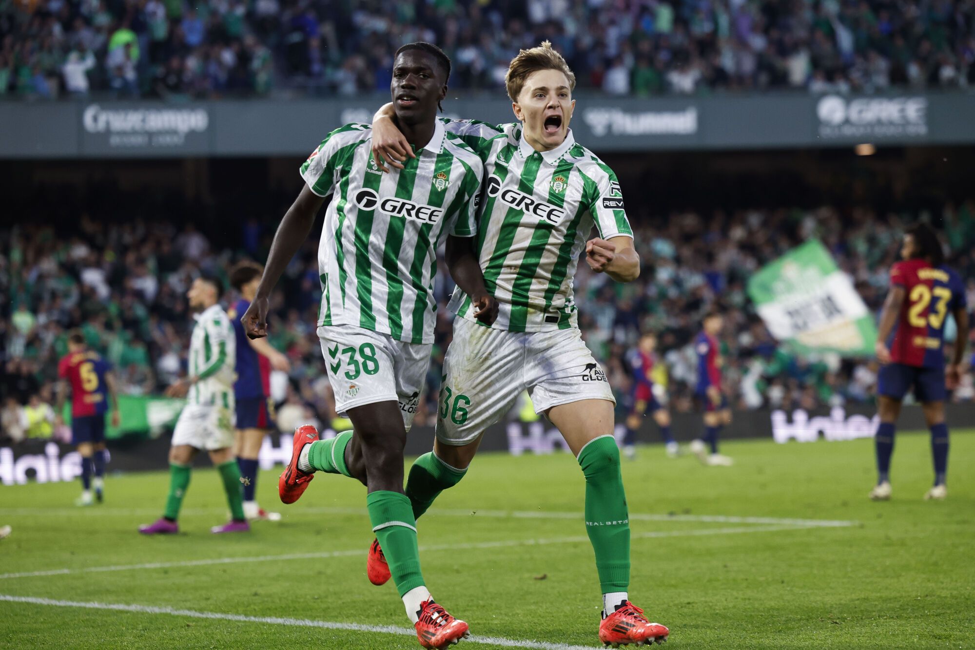 El delantero español del Betis Assane Diao (i) celebra con su compañero Jesús Rodríguez (d) tras marcar el 2-2 durante el partido de la jornada décimo sexta de LaLiga EA Sports que disputaron Real Betis Balompié y FC Barcelona en el Estadio Benito Villamarín de Sevilla. EFE/ Julio Muñoz. (Betis) (Barcelona)