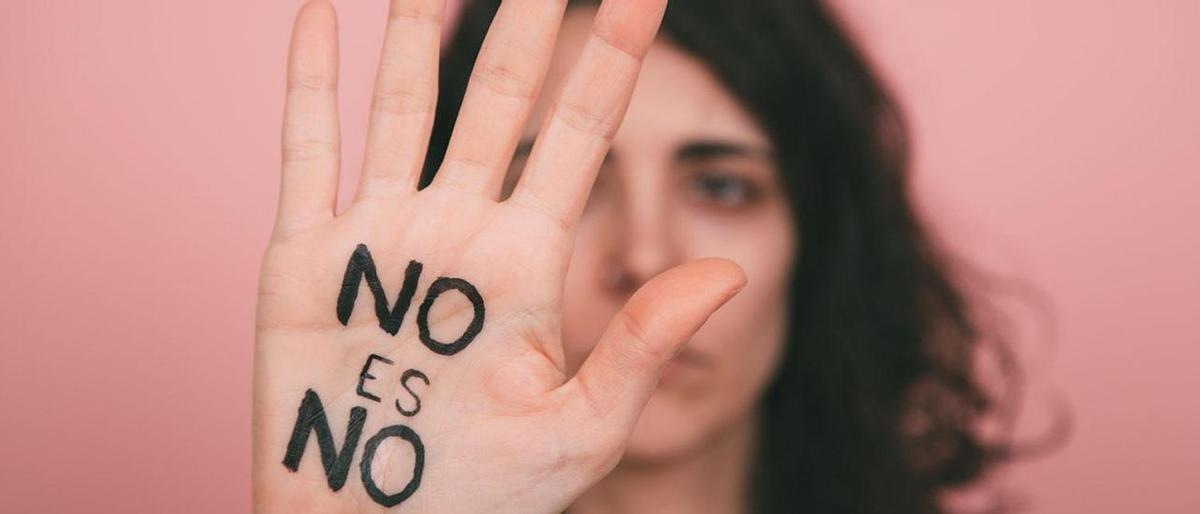 Una mujer levanta la mano en señal de protesta con el mensaje: No es no