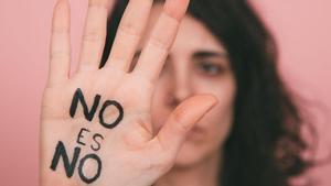 Una mujer levanta la mano en señal de protesta con el mensaje: No es no