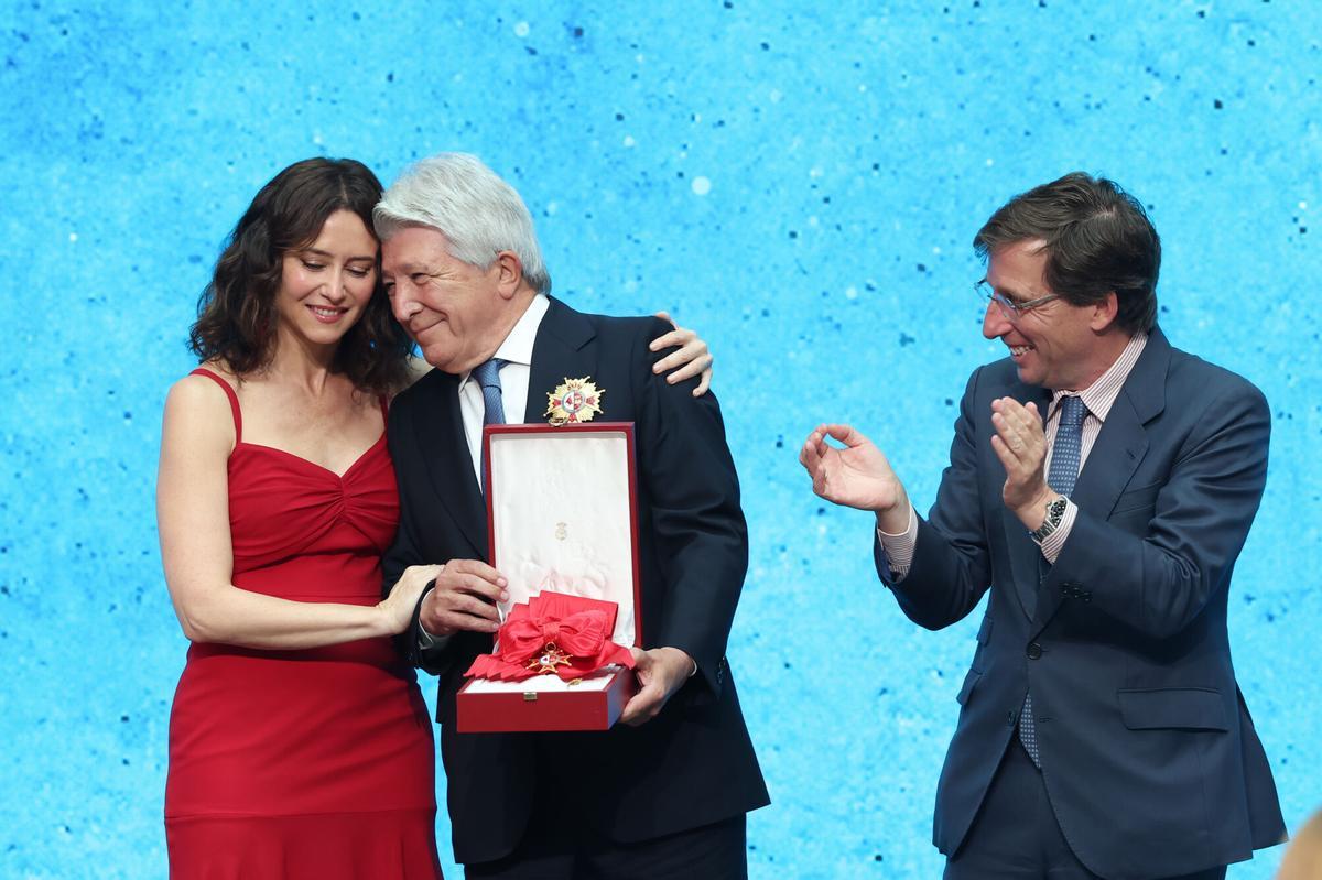 La presidenta de la Comunidad de Madrid, Isabel Díaz Ayuso entrega al presidente de del Atlético de Madrid, Enrique Cerezo, una de las Cruces de la Orden del Dos de Mayo, en presencia del alcalde de Madrid, José Luis Martínez Almeida, durante el acto de entrega de estos galardones que ha tenido lugar en la Real Casa de Correos. EFE/Kiko Huesca