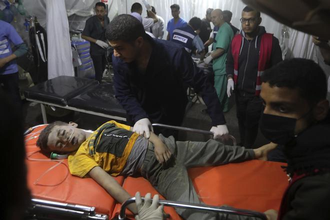 NOTA EDS: CONTENIDO GRÁFICO - Un joven palestino gravemente herido en el bombardeo israelí de la Franja de Gaza es llevado al hospital kuwaití en el campo de refugiados de Rafah, en el sur de la Franja de Gaza, el viernes 19 de abril de 2024 por la noche. (Foto AP/Ismael Abu Dayyah)