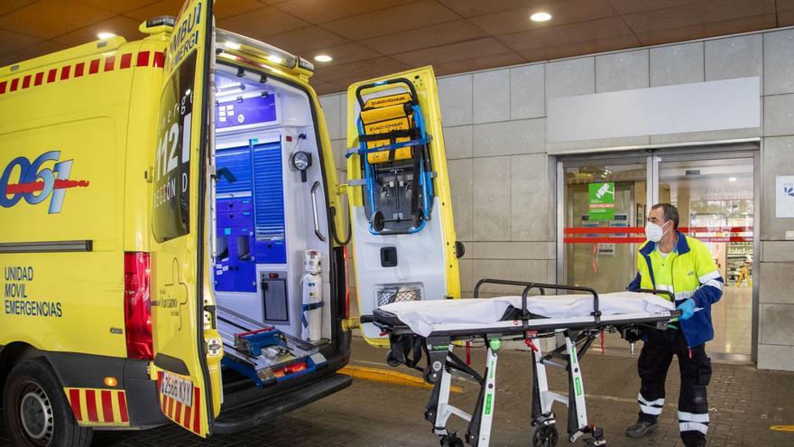 Un trabajador del 061 introduce una camilla en una ambulancia a las puertas del Reina Sofía.  | FRANCISCO PEÑARANDA