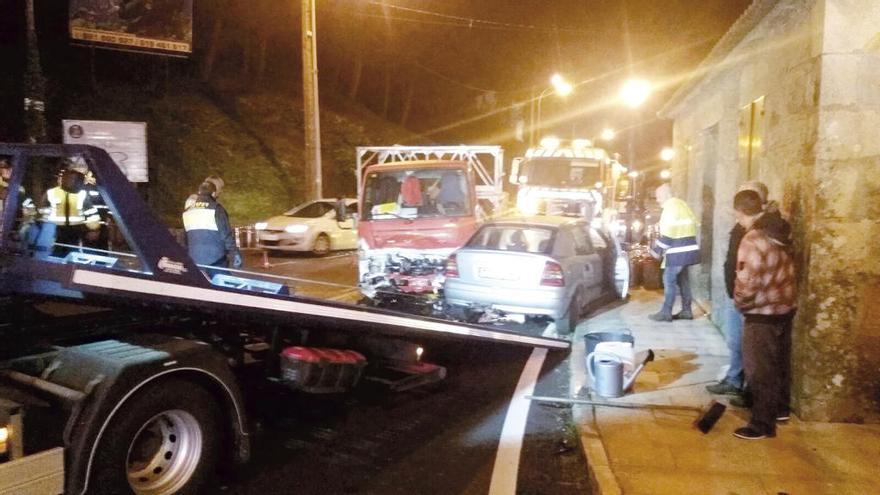 Una grúa recoge uno de los coches accidentados tras ser embestidos por el camión de butano. // E.V.