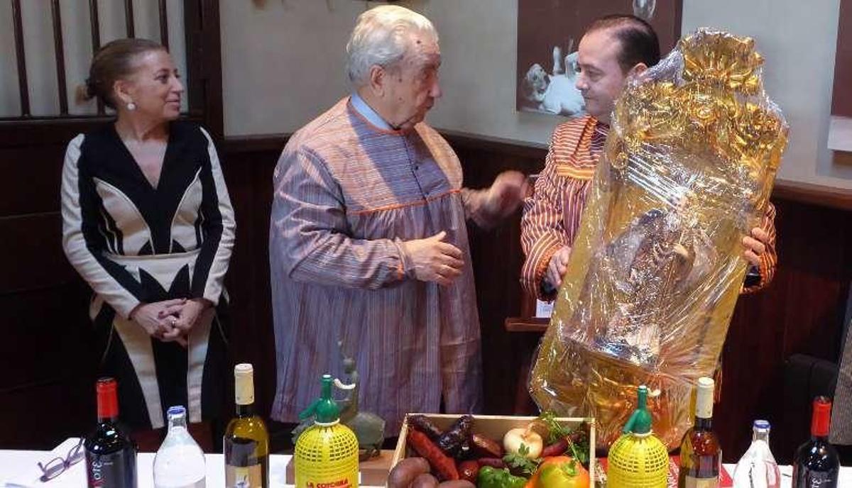 Gil Martínez, en el centro, entrega el retablo a José Gómez, en presencia de Amparo Antuña.