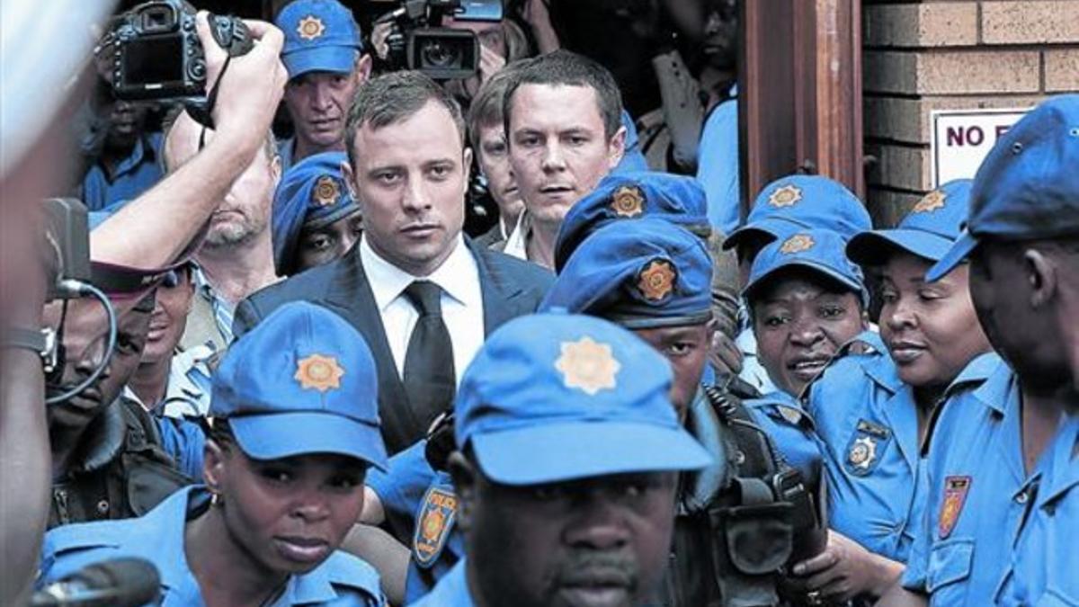Oscar Pistorius sale de los juzgados, custodiado por los policías, ayer en Pretoria.