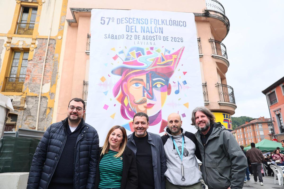 Por la izquierda, Adrián Barbón, Magaly Rubio, Julio García, Roberto Morán y Pablo Vázquez, ante el cartel anunciador del Descenso Folklórico.