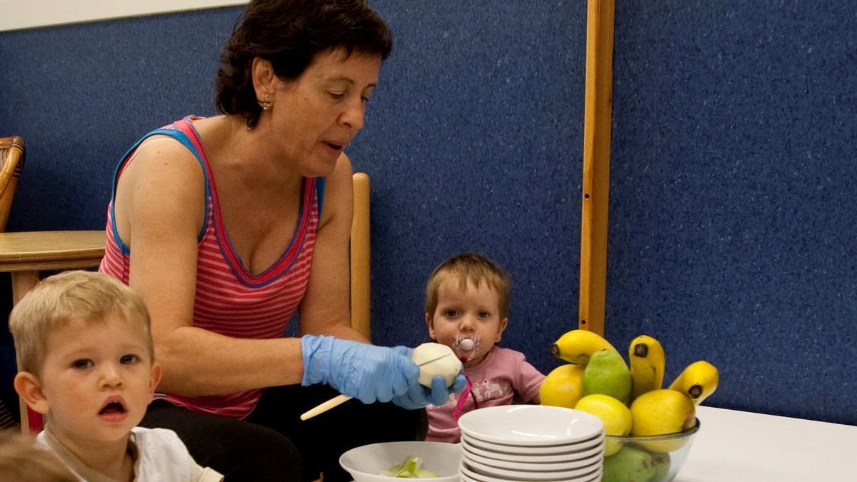 Niños de una guardería, a punto de comer fruta