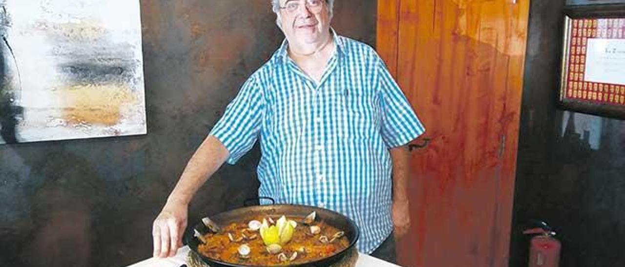 El orgulloso cocinero ante su paella otoñal.