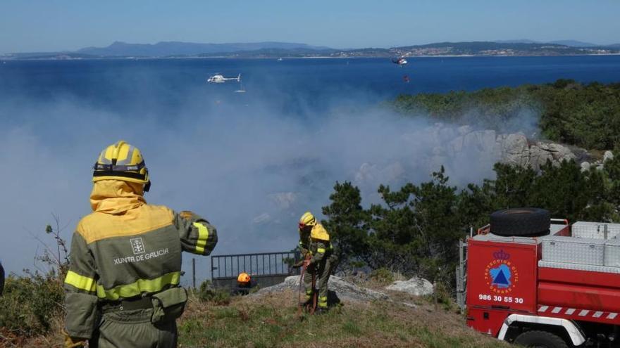 Medios aéreos y terrestres luchan contra el fuego en Punta Couso, en Cangas