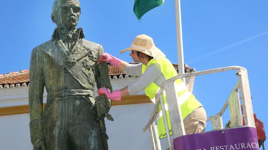 Una operaria adecenta la estatua de Marqués del Duero.