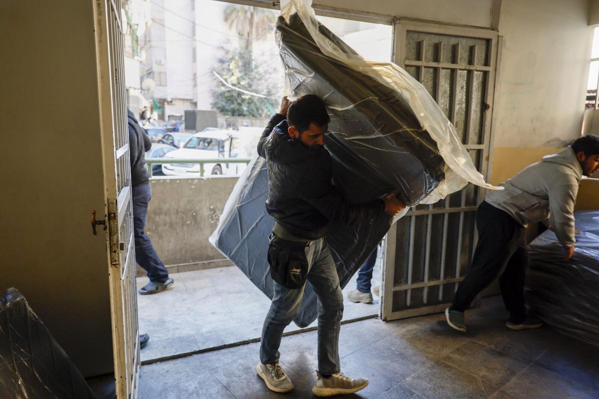 Un voluntario lleva mantas para los residentes desplazados en una escuela local utilizada como refugio en Beirut, Líbano, 9 de marzo de 2026.
