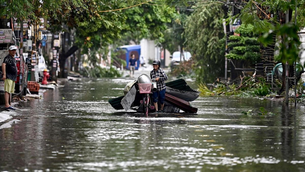 Una mujer recoge escombros en una calle inundada tras el azote del supertifón Yagi en Hai Phong, norte de Vietnam.