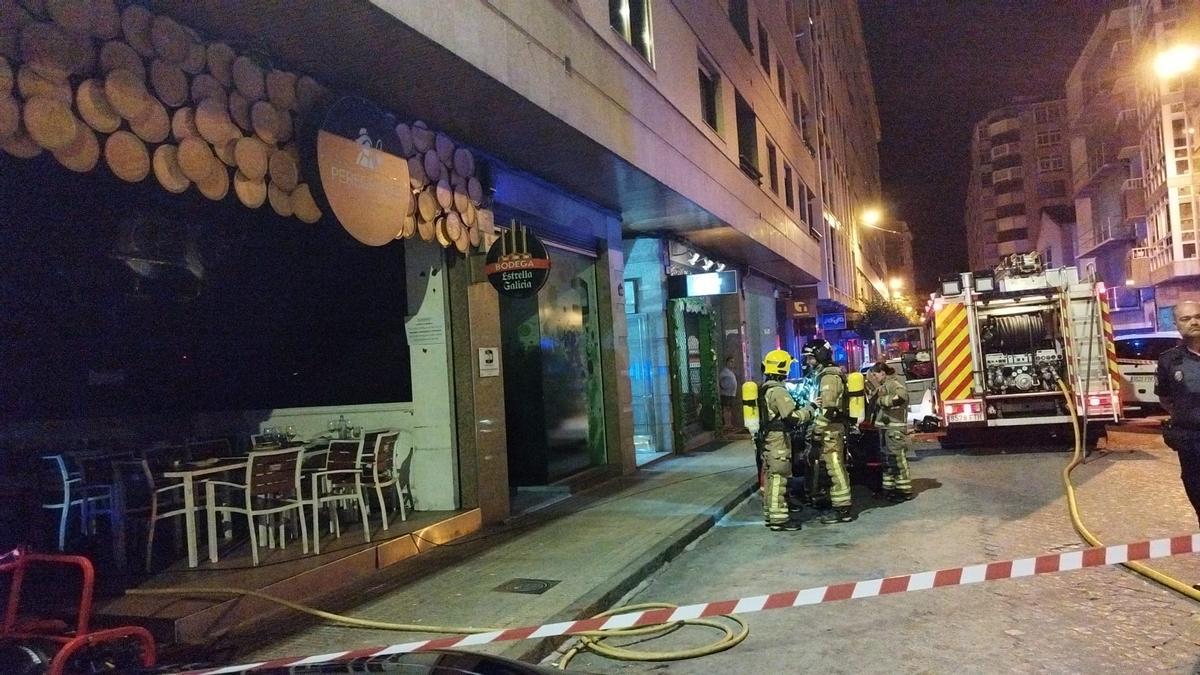 Bomberos sofocando las llamas en el incendio de un restaurante en Ourense que obligó a desalojar un edificio.