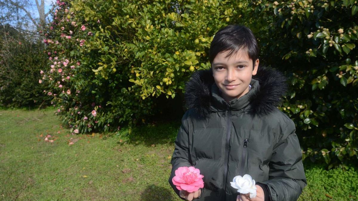 Un niño sostiene dos de las flores que se pueden observar estos días en Rubiáns.. |   // NOÉ PARGA