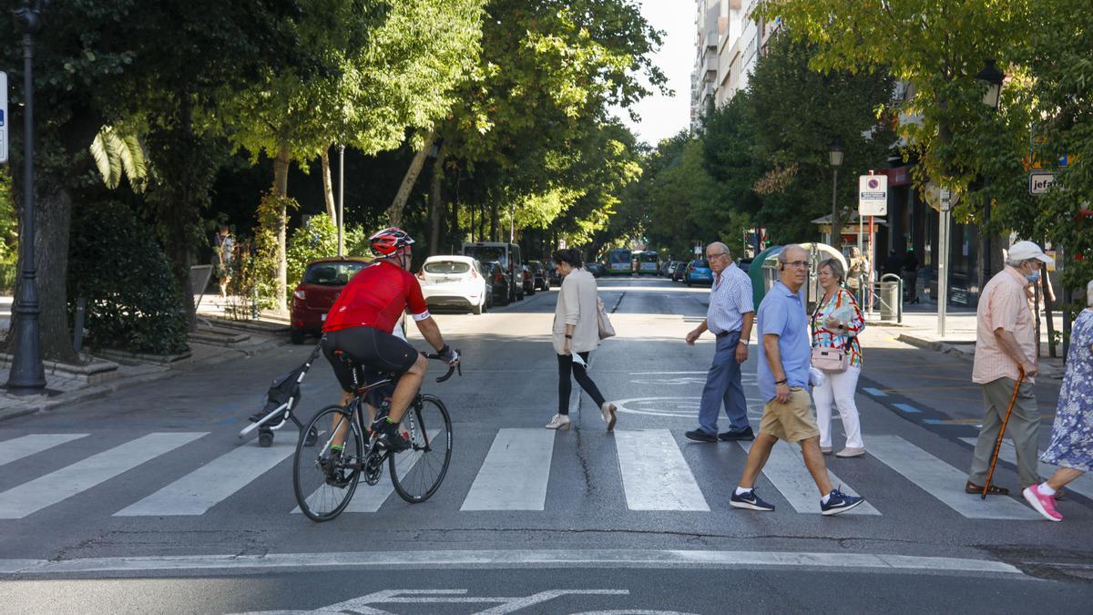 Viandantes cruzan la calzada en Cánovas, solo abierta a buses, taxis, bicis, patinetes, emergencias y residentes.