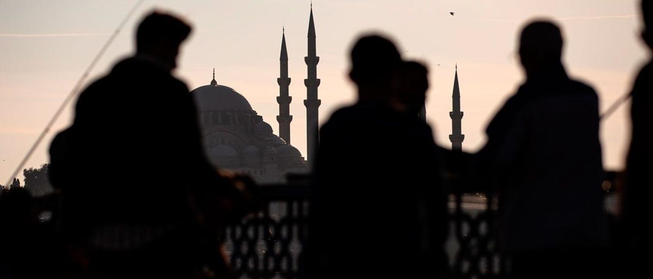 Varias personas caminan junto al puente de Galata.