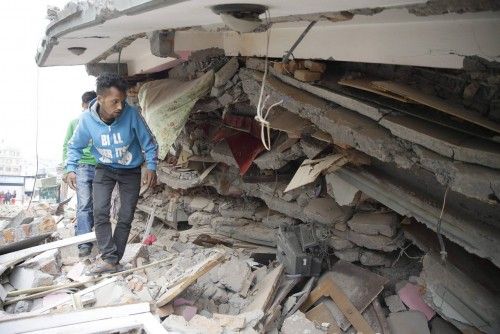Un hombre inspecciona un edificio derrumbado para buscar víctimas, el día después del terremoto