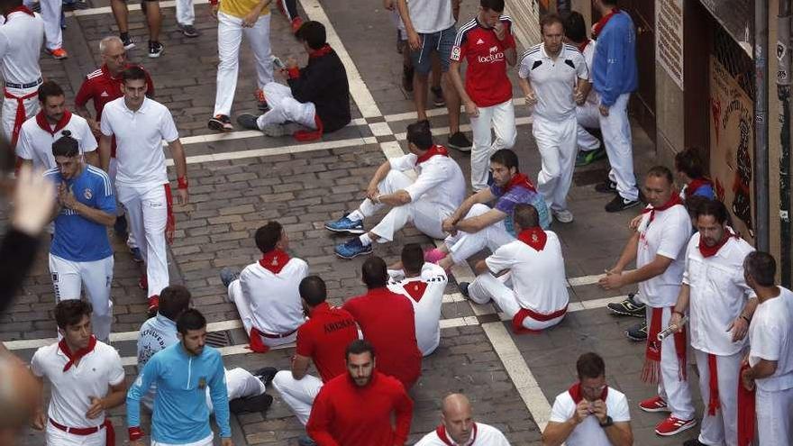 Mozos sentados durante la protesta en la curva de Mercaderes. // EFE