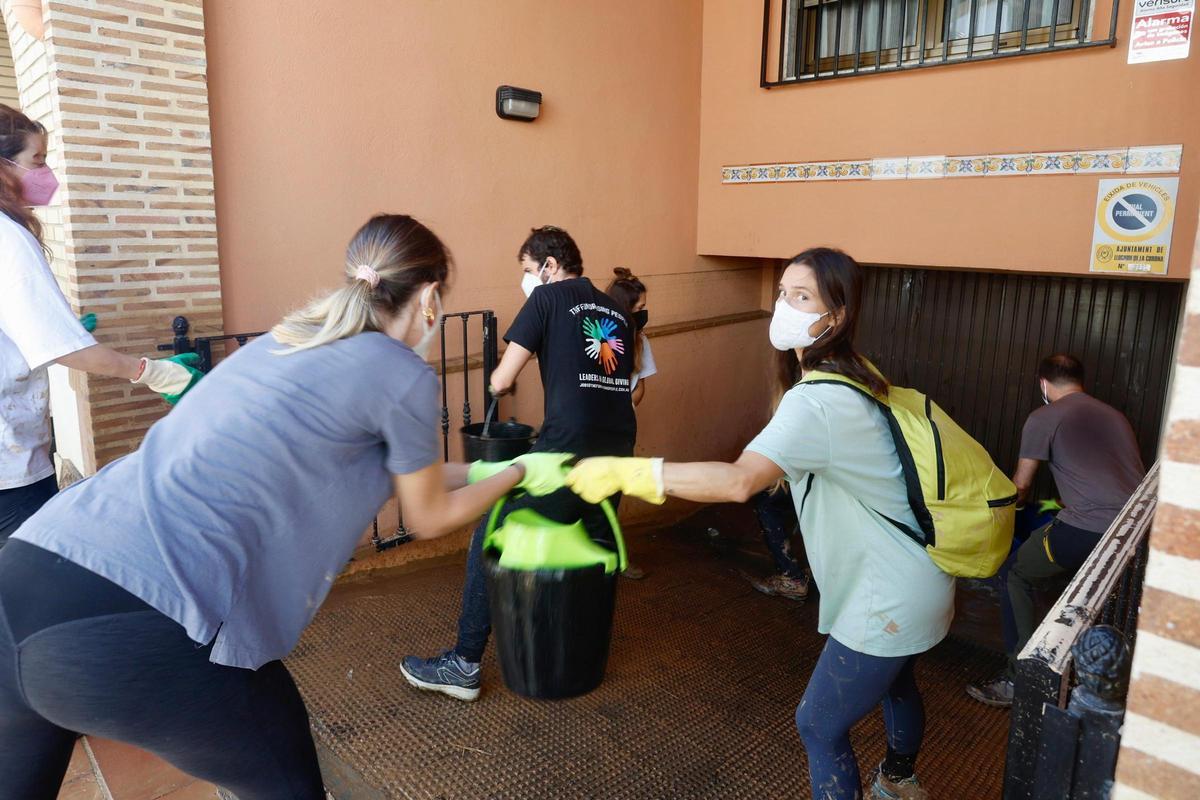 Achicando agua con cubos de un garaje de Llocnou.