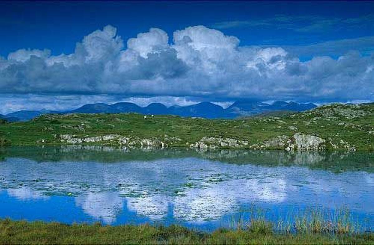 Reflejo de la cadena montañosa Twelve Pins en un lago en Connemara.