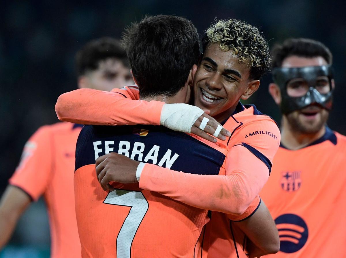 Barcelona's Spanish forward #07 Ferran Torres celebrates with Barcelona's Spanish forward #10 Lamine Yamal after scoring a hat-trick during the Spanish league football match between Real Betis and FC Barcelona at Benito Villamarin Stadium in Seville on December 6, 2025. (Photo by CRISTINA QUICLER / AFP)