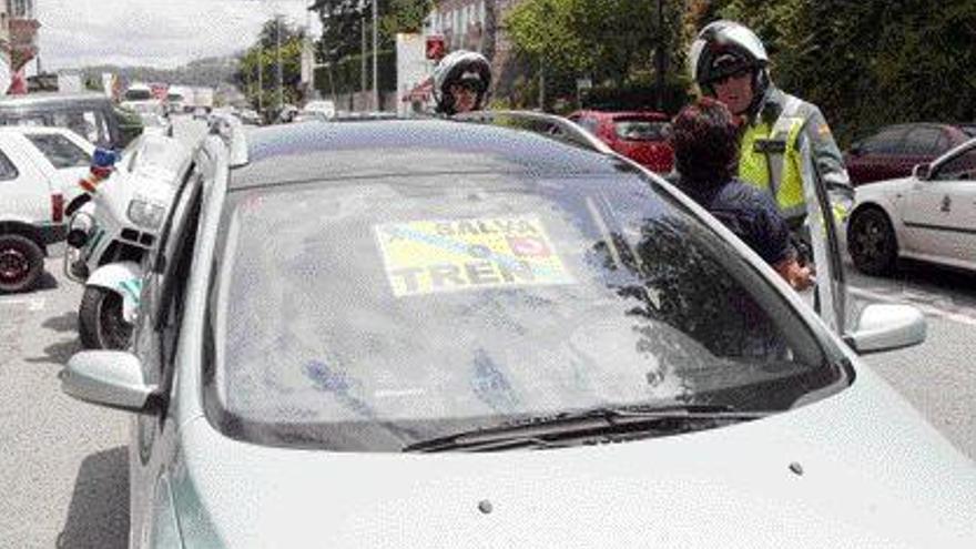 Agentes de la Guardia Civil de Tráfico paran a uno de los integrantes de la caravana llegando a Vigo. / De Arcos