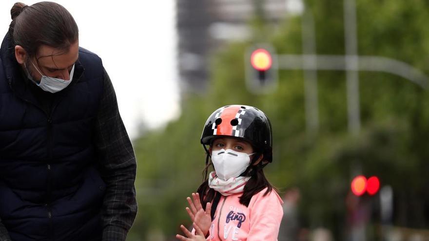 Una niña pasea con su padre en Madrid.