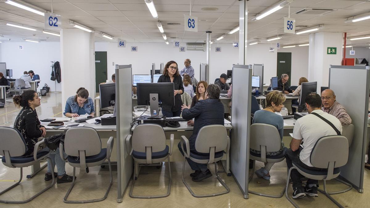 Ciudadanos haciendo la declaracion de la Renta en la Agencia Tributaria.