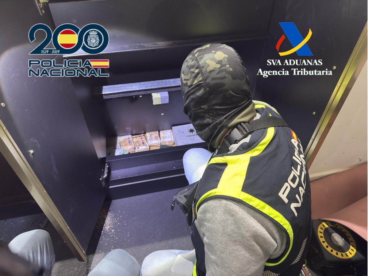 Uno de los agentes, con parte del dinero intervenido.