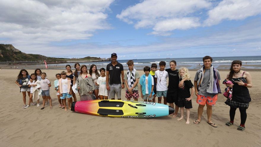 Desde arriba, Carlos Alonso, con un grupo de alumnos; público siguiendo una de las actividades en Salinas, y Carlos Alonso explica las nociones esenciales del Surf Life Saving. | LUISMA MURIAS