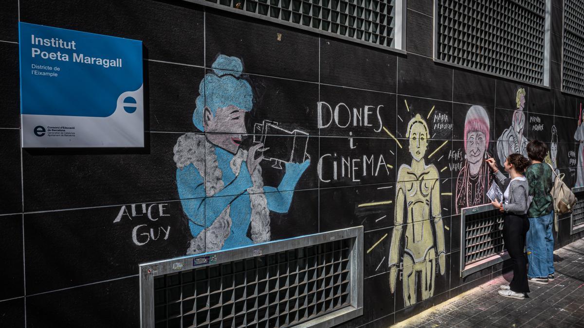 Alumnos del instituto Poeta Maragall de Barcelona pintan un mural sobre mujeres y cine a la pared del edificio, en marzo del 2023.